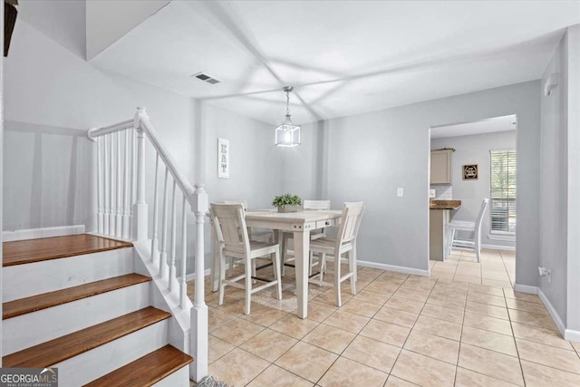 dining room featuring baseboards, stairs, light tile patterned flooring, and visible vents