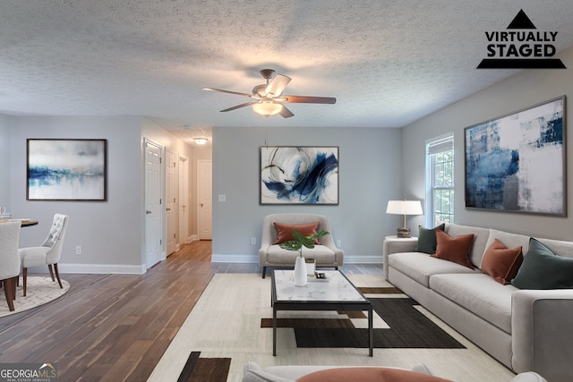 5028 Nichols Dr, Flowery Branch, GA 30542 - living room with wood finished floors, a ceiling fan, and a textured ceiling
