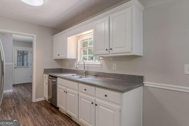 5028 Nichols Dr, Flowery Branch, GA 30542 - kitchen with stainless steel dishwasher, white cabinetry, dark countertops, dark wood-type flooring, and a textured ceiling