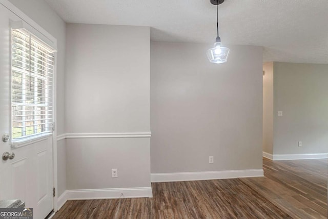 5028 Nichols Dr, Flowery Branch, GA 30542 - unfurnished dining area with wood finished floors, plenty of natural light, and a textured ceiling