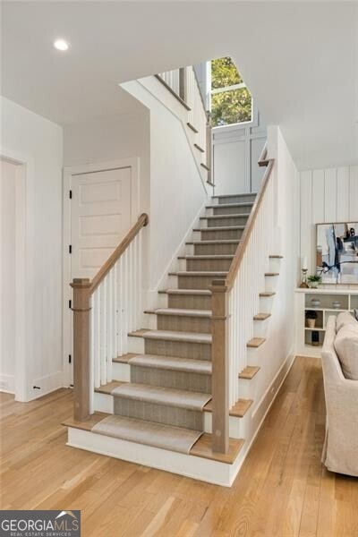 staircase featuring baseboards, recessed lighting, and wood finished floors