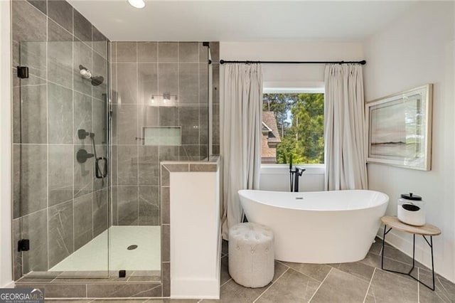 full bathroom with a soaking tub, tile patterned floors, and a shower stall