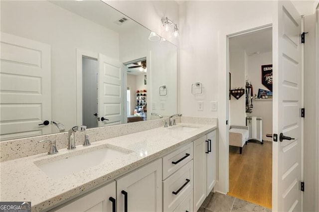 ensuite bathroom featuring connected bathroom, visible vents, and a sink
