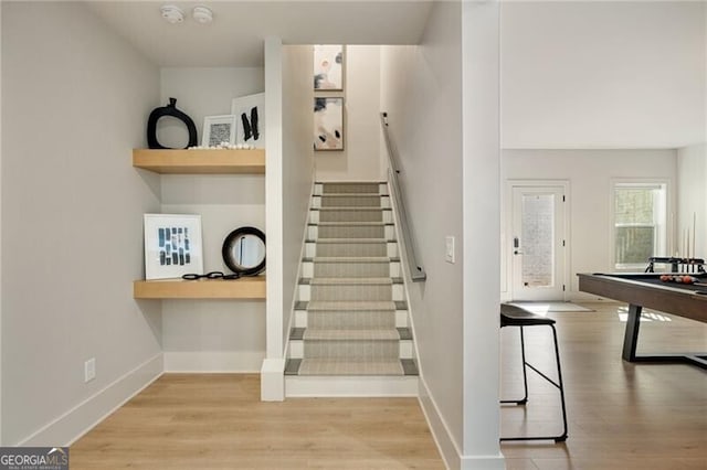 staircase featuring baseboards and wood finished floors