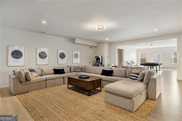 living room featuring baseboards, recessed lighting, and wood finished floors