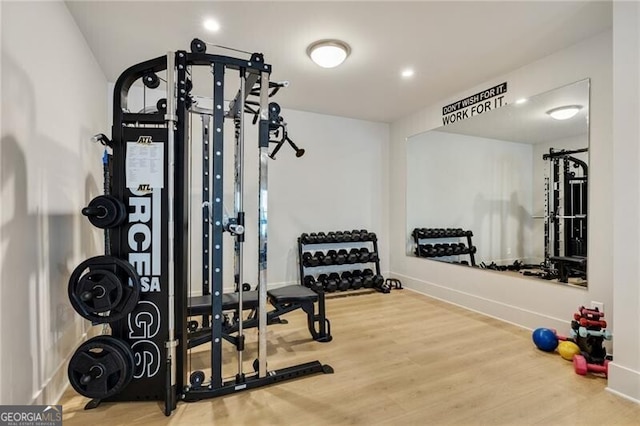 workout area featuring recessed lighting, baseboards, and wood finished floors