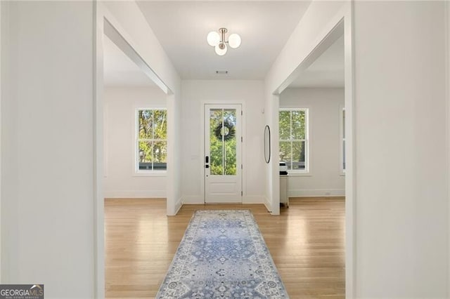 foyer entrance with baseboards and light wood-style flooring