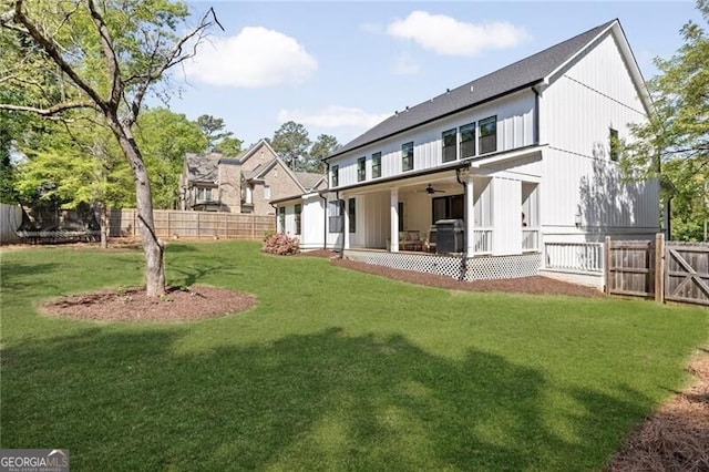 rear view of property featuring a fenced backyard, ceiling fan, a patio, and a lawn