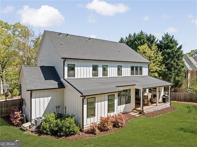 back of property featuring a lawn, board and batten siding, fence, central air condition unit, and a shingled roof