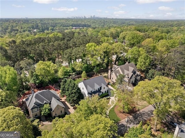 birds eye view of property featuring a forest view