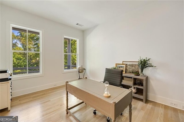 home office with baseboards, light wood-style flooring, and visible vents