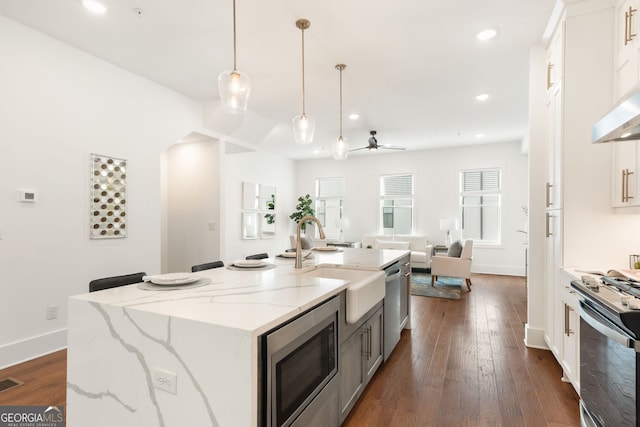 kitchen featuring a sink, stainless steel appliances, white cabinetry, and open floor plan