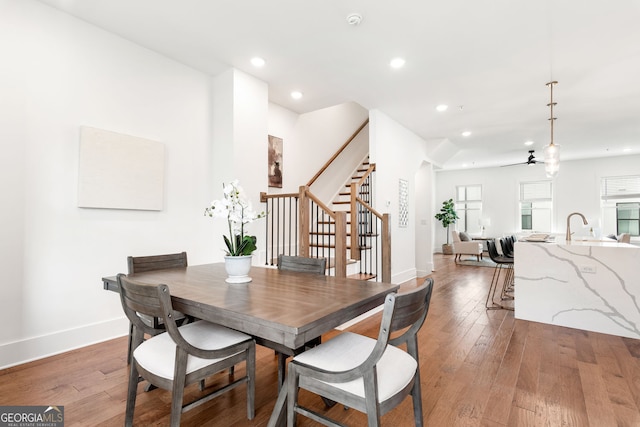 dining room with stairs, baseboards, and light wood-style flooring