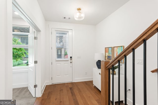 entrance foyer featuring baseboards, visible vents, and wood finished floors