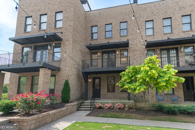 view of front of property with brick siding and a balcony