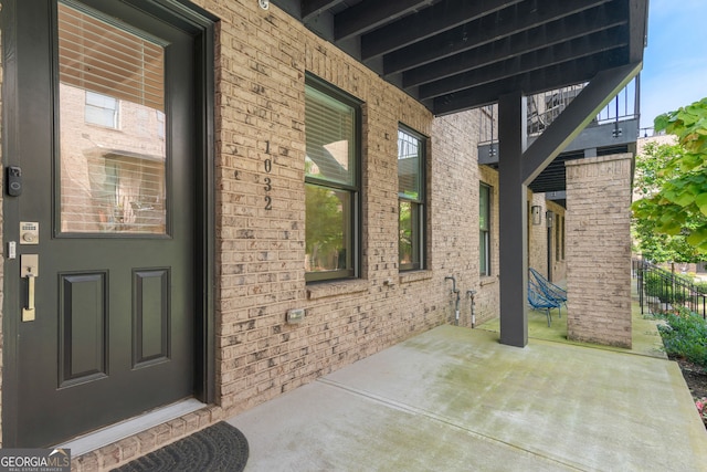 doorway to property featuring a patio area and brick siding
