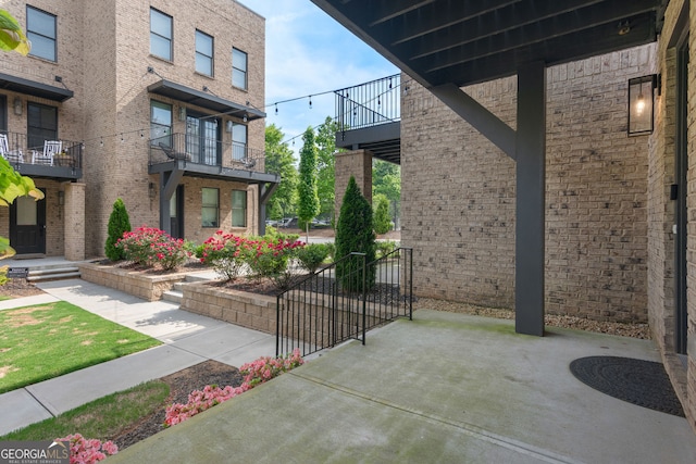 exterior space with brick siding and a balcony