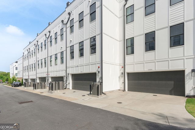 view of building exterior featuring an attached garage and driveway