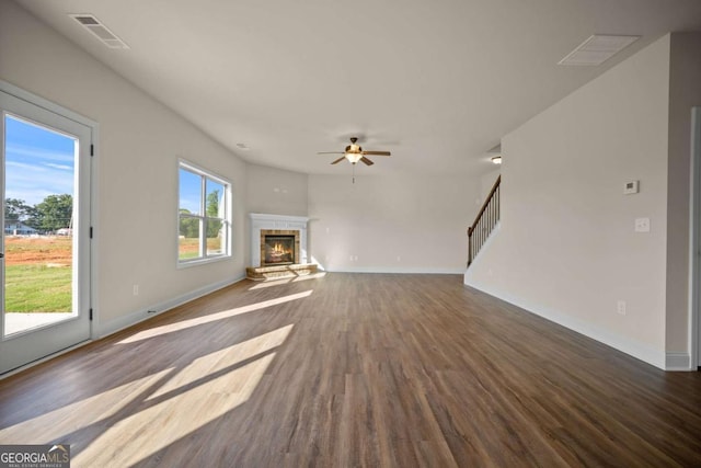 unfurnished living room featuring visible vents, wood finished floors, a fireplace, baseboards, and ceiling fan
