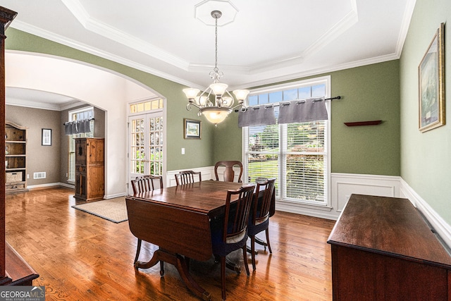 139 Ardsley Run, Canton, GA 30115 - dining space with arched walkways, a tray ceiling, wood finished floors, a chandelier, and crown molding