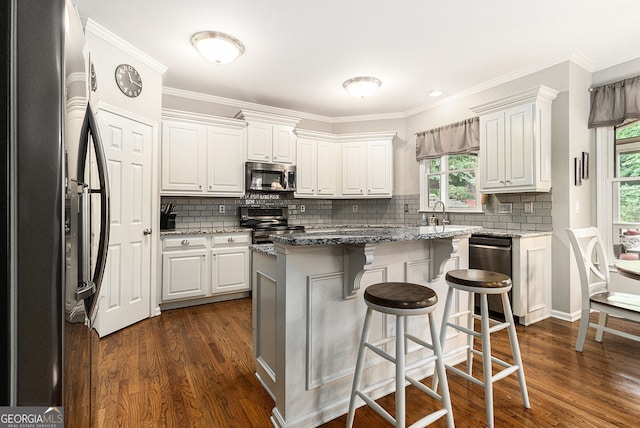 139 Ardsley Run, Canton, GA 30115 - kitchen featuring appliances with stainless steel finishes, dark wood finished floors, white cabinetry, and crown molding