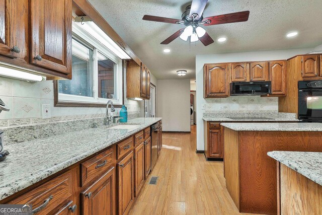 337 Andrew Bailey Rd, Sharpsburg, GA 30277 - kitchen featuring black appliances, light wood finished floors, brown cabinets, light stone countertops, and a textured ceiling