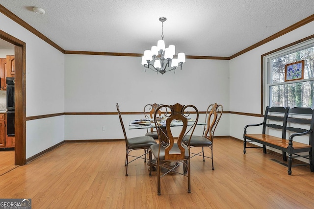 337 Andrew Bailey Rd, Sharpsburg, GA 30277 - dining area with light wood-style flooring, a chandelier, a textured ceiling, and crown molding
