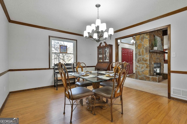 337 Andrew Bailey Rd, Sharpsburg, GA 30277 - dining space with light wood-style floors, a chandelier, a textured ceiling, and crown molding