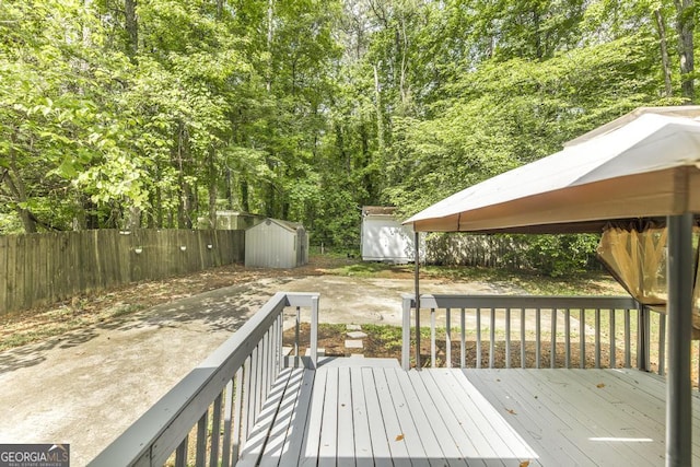 522 Wilderness Dr, Macon, GA 31220 - wooden terrace featuring a storage unit, an outbuilding, and fence