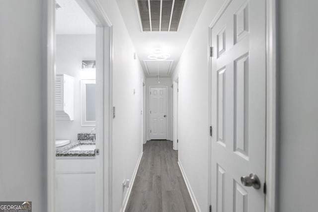 522 Wilderness Dr, Macon, GA 31220 - corridor with attic access, light wood-type flooring, a sink, and baseboards