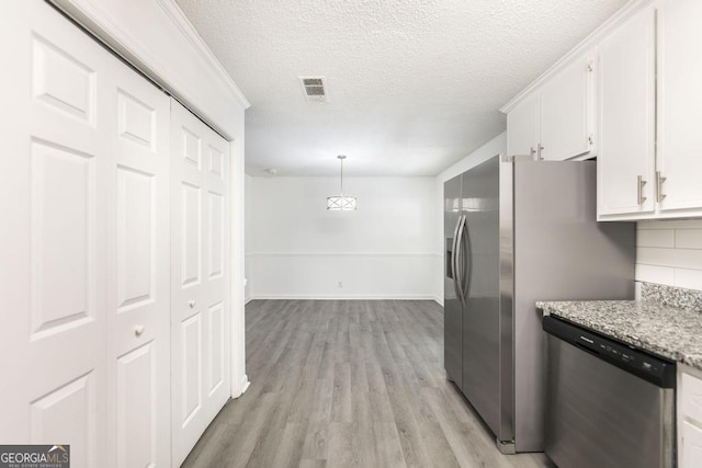 522 Wilderness Dr, Macon, GA 31220 - kitchen with stainless steel appliances, white cabinets, light wood-style floors, backsplash, and a textured ceiling