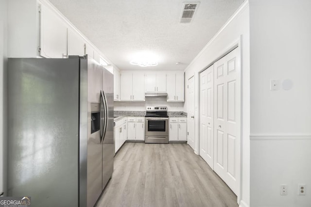 522 Wilderness Dr, Macon, GA 31220 - kitchen featuring appliances with stainless steel finishes, under cabinet range hood, light wood-style flooring, white cabinets, and a textured ceiling