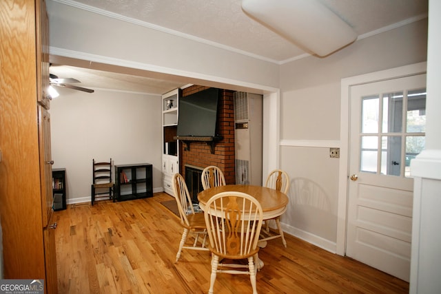 603 E Main St, Thomaston, GA 30286 - dining area with a brick fireplace, a ceiling fan, light wood finished floors, ornamental molding, and baseboards