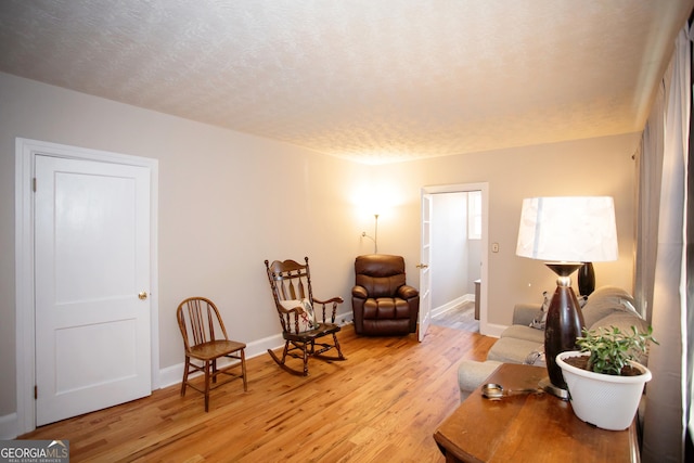 603 E Main St, Thomaston, GA 30286 - living area featuring light wood-type flooring, a textured ceiling, and baseboards