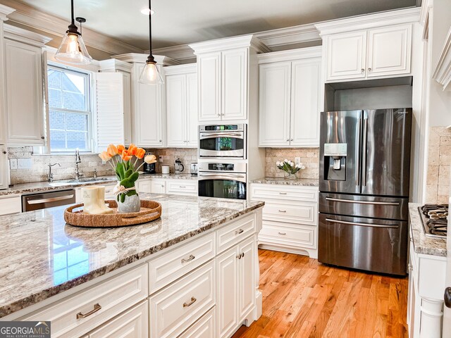 kitchen featuring a sink, appliances with stainless steel finishes, and white cabinets