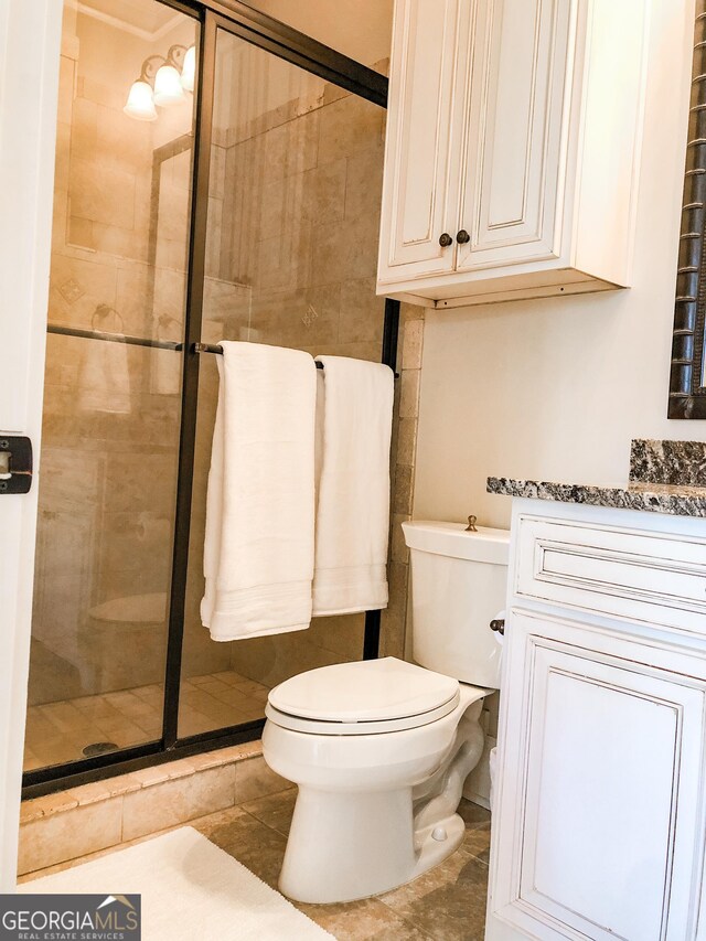 full bath featuring tile patterned flooring, toilet, and a shower stall