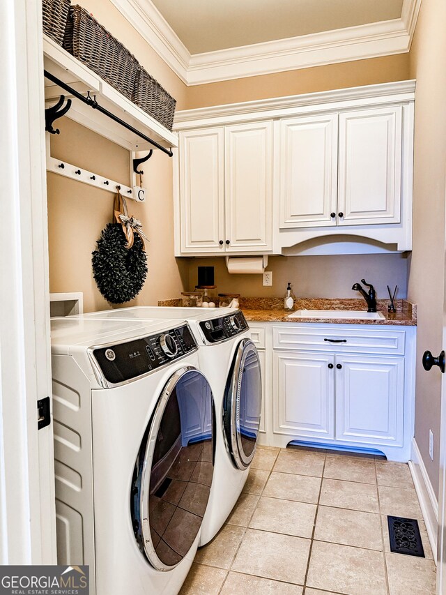 clothes washing area featuring crown molding, separate washer and dryer, a sink, cabinet space, and light tile patterned floors