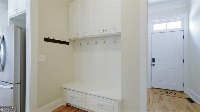 mudroom with baseboards, light wood-style flooring, and visible vents