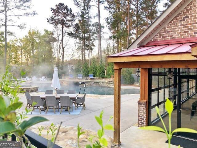 view of patio / terrace with an outdoor pool and outdoor dining space