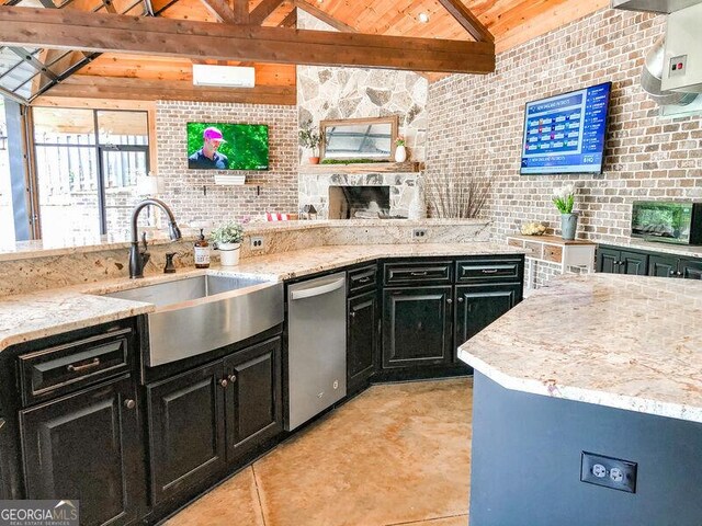kitchen featuring dark cabinetry, light stone countertops, a sink, and dishwasher