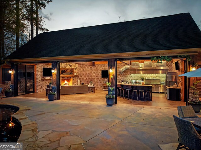 view of patio / terrace featuring an outdoor living space, exterior kitchen, and outdoor dry bar