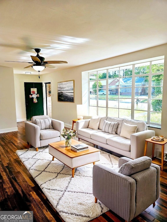 living room with baseboards, dark wood finished floors, and ceiling fan