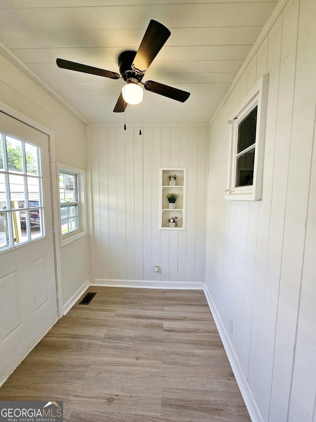 unfurnished room featuring baseboards, a ceiling fan, light wood finished floors, and visible vents