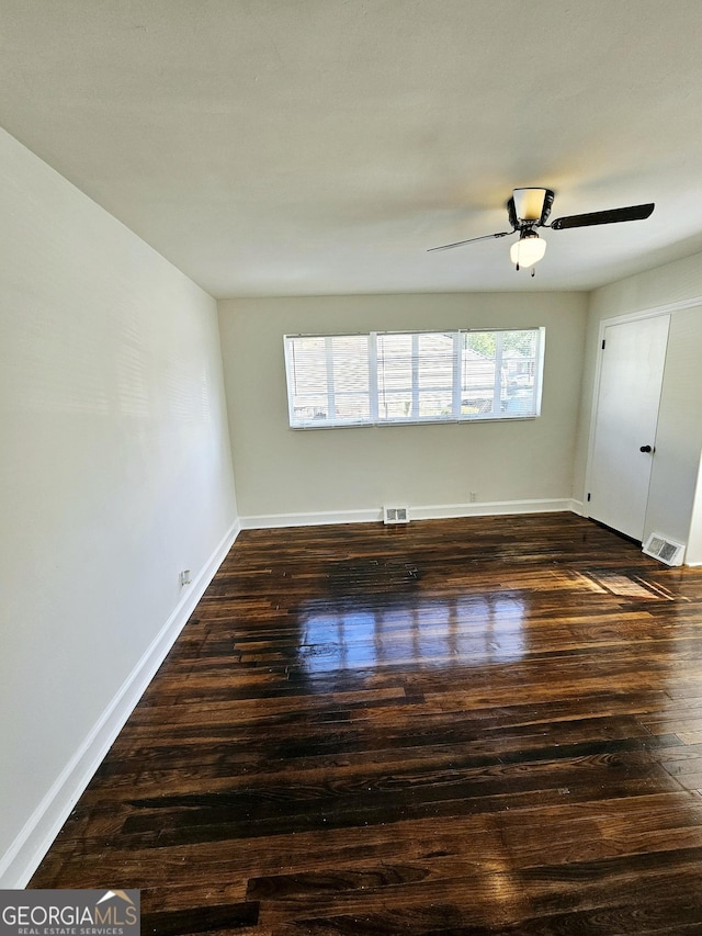 unfurnished room with baseboards, visible vents, and wood finished floors