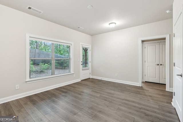 unfurnished room with visible vents, baseboards, and wood finished floors