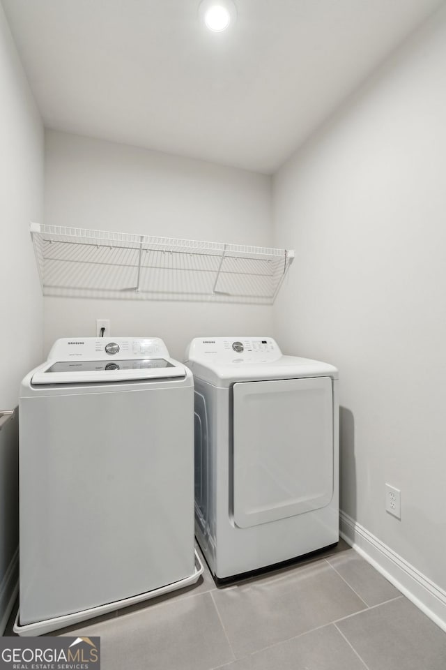 laundry area featuring laundry area, baseboards, independent washer and dryer, and tile patterned flooring