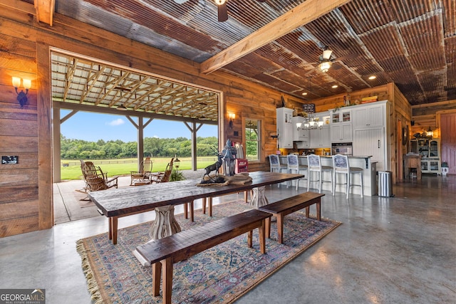 290 Weldon Rd, Fayetteville, GA 30215 - dining room featuring ceiling fan with notable chandelier, wood walls, and concrete floors