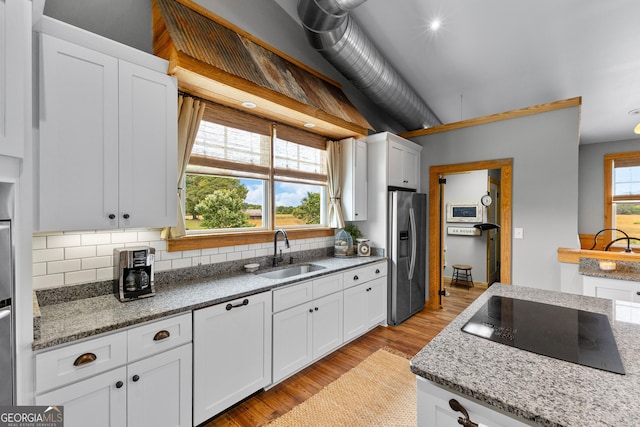 290 Weldon Rd, Fayetteville, GA 30215 - kitchen featuring white cabinetry, black electric stovetop, stainless steel fridge, and a sink