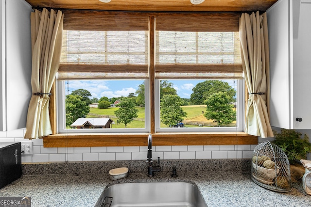290 Weldon Rd, Fayetteville, GA 30215 - room details featuring a sink, tasteful backsplash, and light stone countertops