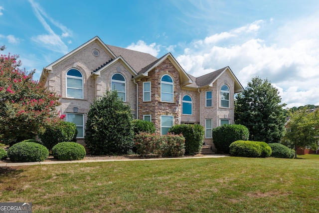 view of front of property featuring brick siding and a front lawn